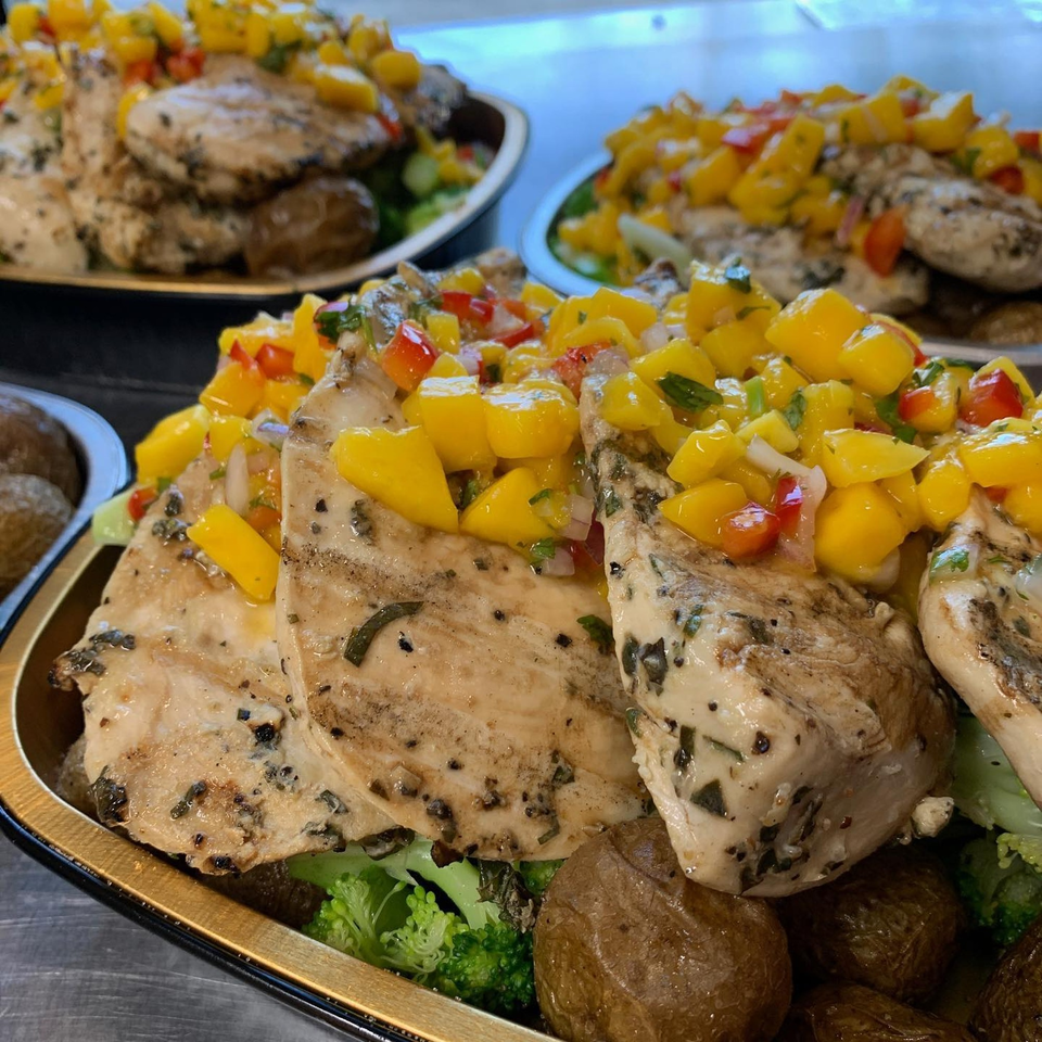 Grilled chicken breasts topped with mango salsa, served with roasted potatoes and broccoli.
